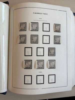 un livre ouvert avec des timbres, posé sur une table