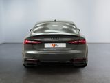 the rear end of a grey audi sedan parked in a showroom