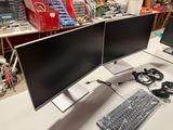 two computer monitors sitting on a desk with a keyboard and mouse