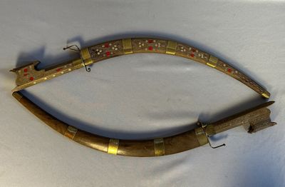 une image représentant un objet métallique d'aspect très ancien posé sur une surface blanche