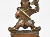 bronze statue of a man with a sword on a wooden base