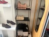 many pairs of shoes on a shelf in a closet