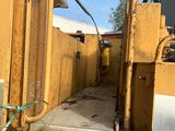 un gros camion jaune garé sur la terre battue