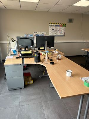 un bureau sur lequel sont posés deux écrans et un ordinateur portable