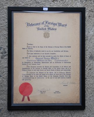 an old document with a red ribbon on it is hanging on a wall
