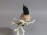 a small figurine of a bird on a branch