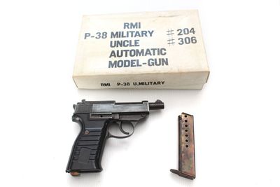 un pistolet et un chargeur posés sur une table à côté d'une boîte