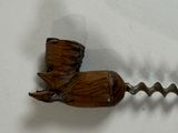 a bottle opener with a wooden handle on a white surface