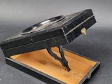 a black box with a wooden lid and a metal object in it