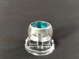 a close up of a silver ring with a blue topaz stone