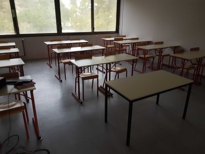 many tables and chairs in a room with a big window