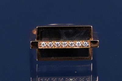 une image représentant une bague en or sertie de diamants sur un fond bleu