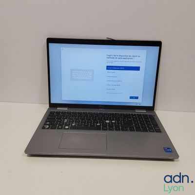 un ordinateur portable ouvert posé sur une table blanche