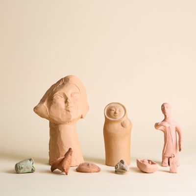 plusieurs figurines en argile de formes et de tailles variées, posées sur une surface blanche