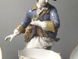 a figurine of a woman holding a basket of grapes