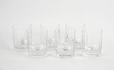 six clear glasses are lined up in a row on a white surface