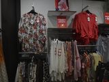 a lot of clothes hanging on a rack in a store