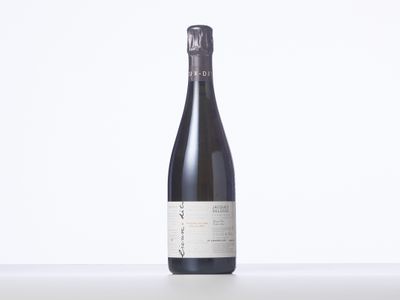 une bouteille de vin posée sur une table blanche