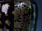 a black vase with gold designs on it on a blue background