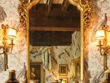 une cheminée sur laquelle sont posés un miroir et une horloge