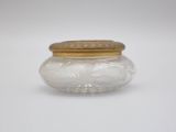 a small glass jar with a gold lid on a white surface