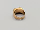 a close up of a gold ring on a white surface
