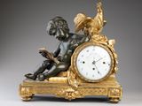 une petite statue représentant un garçon assis sur une horloge
