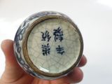 a small blue and white vase with chinese writing on it