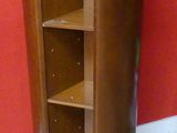 une grande armoire en bois avec des étagères, placée dans un coin