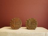 two small coins sitting on top of a white table