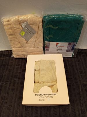 a box of towels and a pair of bathrobes on the floor