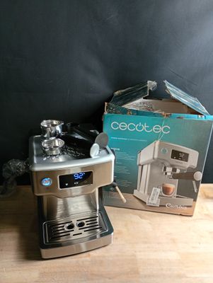 une cafetière en argent et une boîte posées sur une table en bois