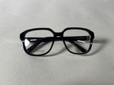 une paire de lunettes posée sur une table, sur fond blanc