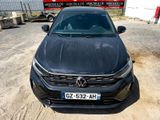 the front view of a black volkswagen car parked in a parking lot