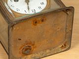 an old clock that is sitting on a wooden table