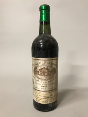 une vieille bouteille de vin posée sur une table blanche