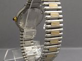 un gros plan d'une montre posée sur un présentoir transparent