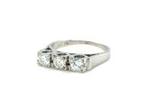 a close up of a three stone diamond ring on a white background
