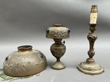 two antique brass candlesticks and a vase on a white background