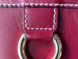 a close up of a red purse with a metal ring