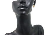 a black mannequin head with a pair of earrings on it