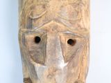 a wooden mask that has a face on it