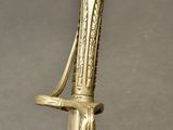 brass plated sword with a decorative handle and sheath