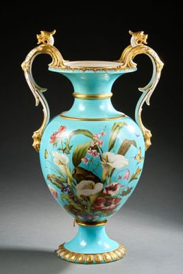 un vase bleu sur lequel sont peints un oiseau et des fleurs