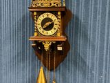 une horloge accrochée au mur par une chaîne