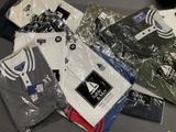 de nombreux t-shirts emballés dans du plastique, posés sur une table
