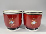 pair of red and white vases with blue flowers on them