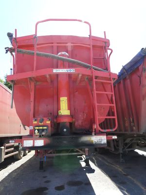 un gros camion rouge garé à côté d'un train
