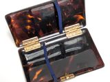 a tortoise shell case with a blue ribbon around it