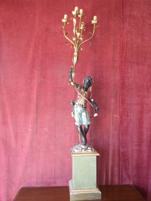statue of a boy holding a candelabra on a pedestal